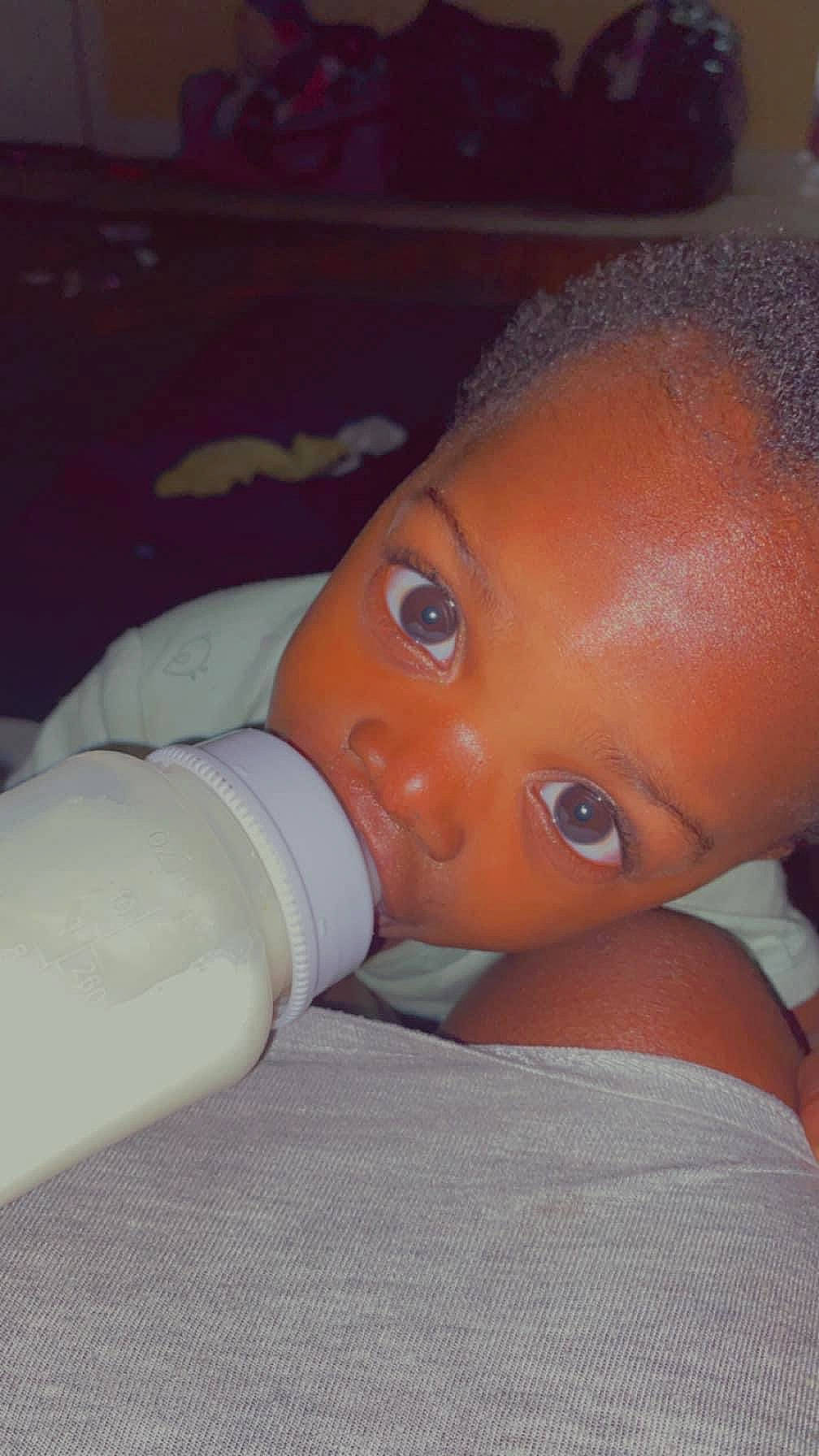 Messiah is registered to the contest to win money with this photo: baby, baby_bottle, baby_toddler_clothing, bottle, cheek, drinkware, ear, eye, eyebrow, eyelash, human_body, infant_formula, iris, lip, mouth, nail, nose, person, plastic_bottle, skin