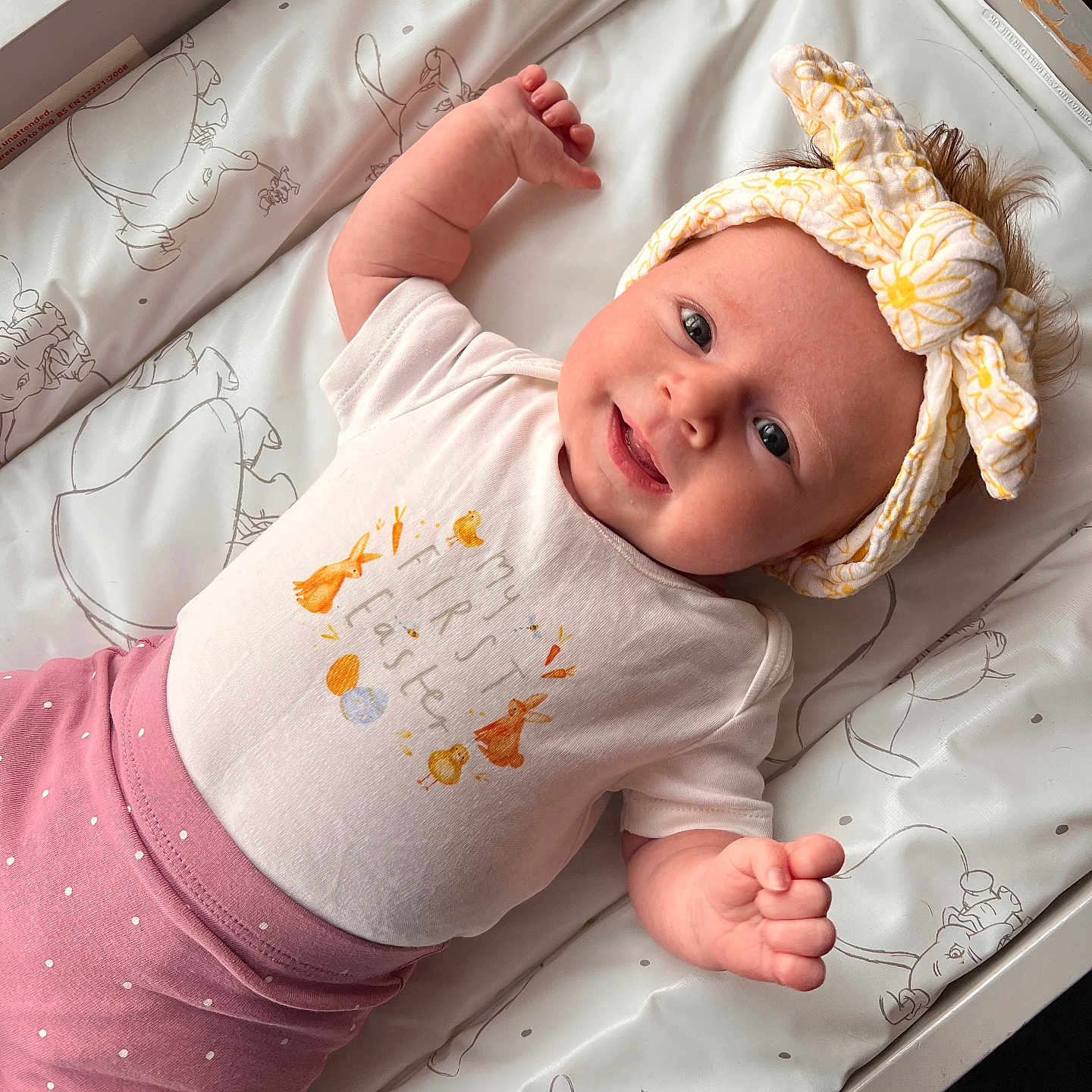 Charlotte is registered to the contest to win money with this photo: baby, bow, changing_pad, child, closeup, cute, easter_theme, happy, headband, indoor, infant, lying_down, patterned, person, pink_pants, polka_dots, portrait, smiling, soft_light, white_shirt
