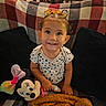 Ariana joined the competition — help win amazing prizes! baby, child, toddler, smiling, portrait, sitting, indoors, couch, plaid, blanket, bow, hair, clothing, toy, stuffed_animal, minnie_mouse, duck, colorful, happy, family_home