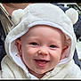 baby, smiling, hood, white, fluffy, cute, child, face, portrait, outdoor, happy, apparel, warm_clothing, person, headwear, closeup, infant, joyful, baby_clothes, soft_texture