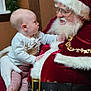 Matthew is registered to the contest to win money with this photo: baby, child, santa_claus, beard, holiday, christmas, festive, red_clothing, glasses, indoor, wood_paneling, garland, curious, face, person, seated, interaction, smiling, white_hair, decor