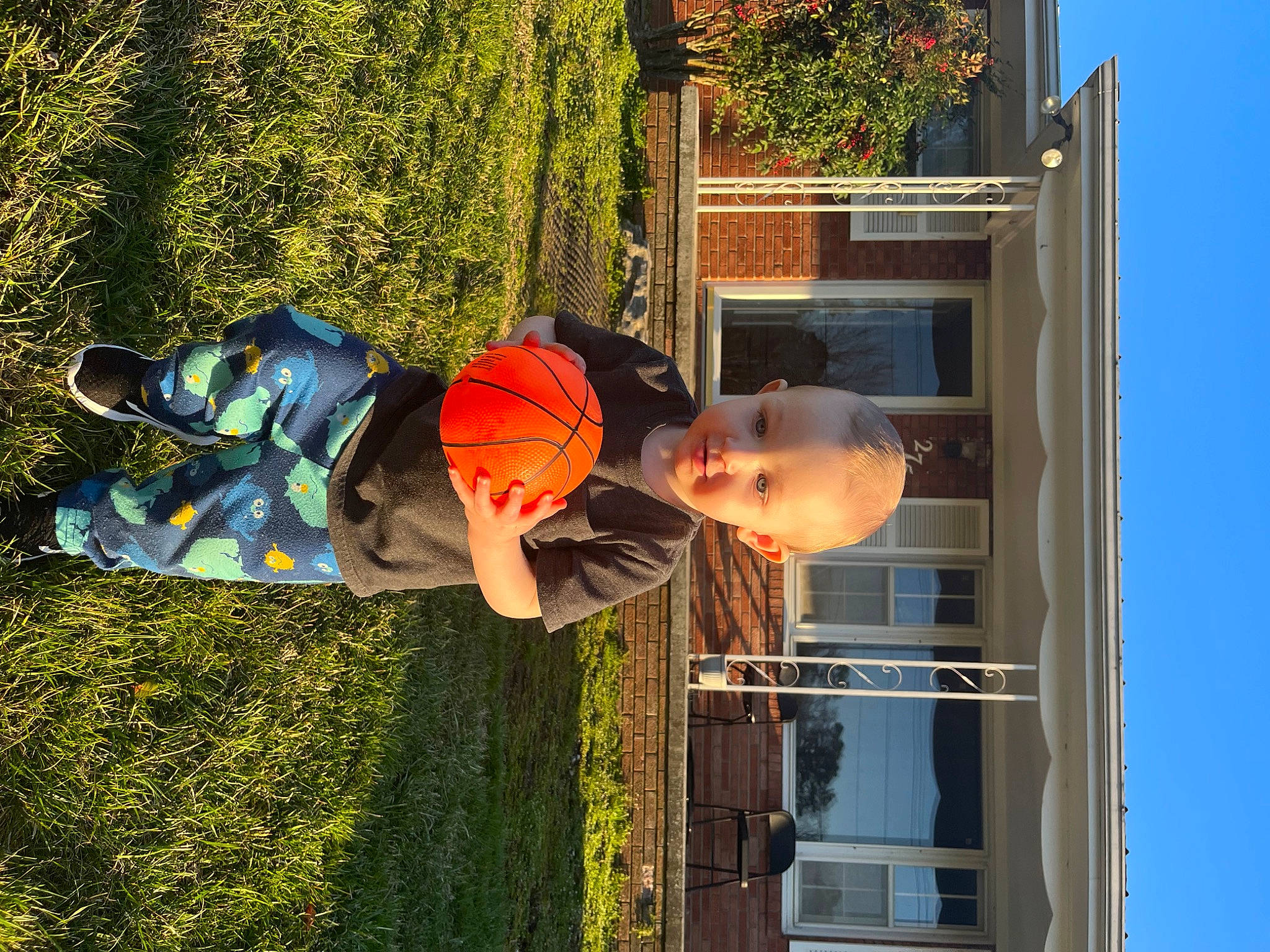 Connor is registered to the contest to win money with this photo: building, door, facade, fun, grass, hat, house, landscape, leisure, people_in_nature, person, plant, shadow, siding, toddler, tree, window, wood, yard