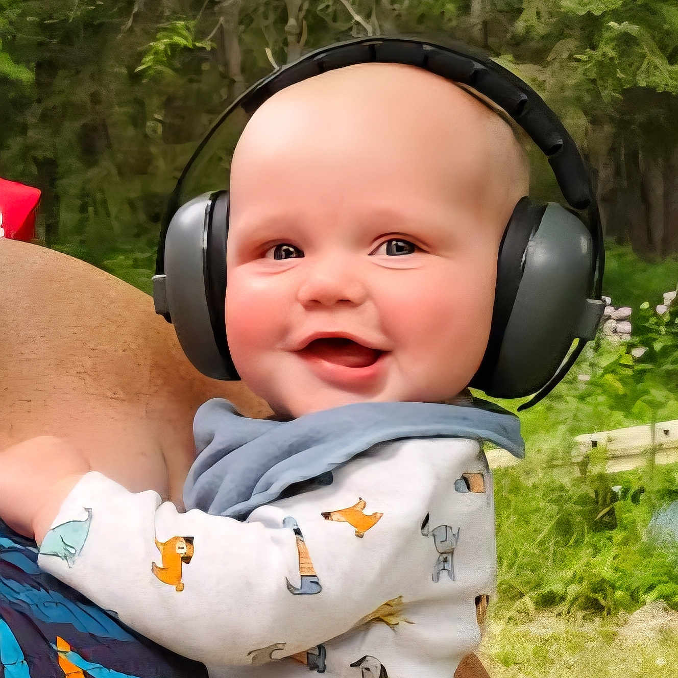 Mavrick joined the competition — help win amazing prizes! adult, baby, baby_clothes, child, clothing, cute, daylight, earmuffs, forest, greenery, happy, head, headphones, holding, infant, nature, outdoor, person, portrait, smile
