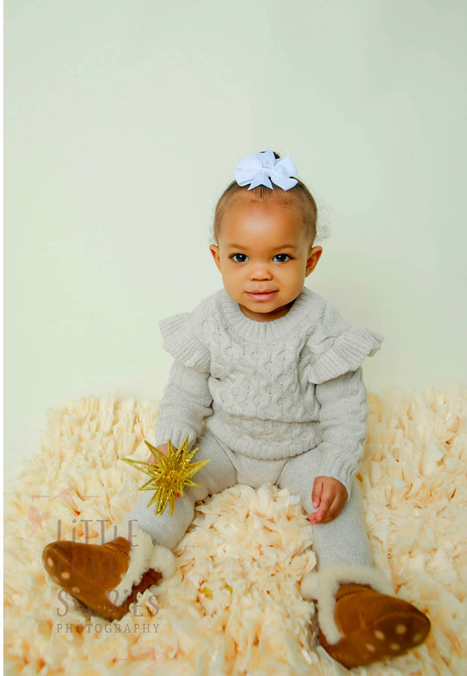 Ariya is registered to the contest to win money with this photo: baby, baby_products, baby_toddler_clothing, beanie, cap, child, comfort, comfort_food, fur, happy, headpiece, linens, person, petal, portrait_photography, room, sitting, sleeve, smile, toddler