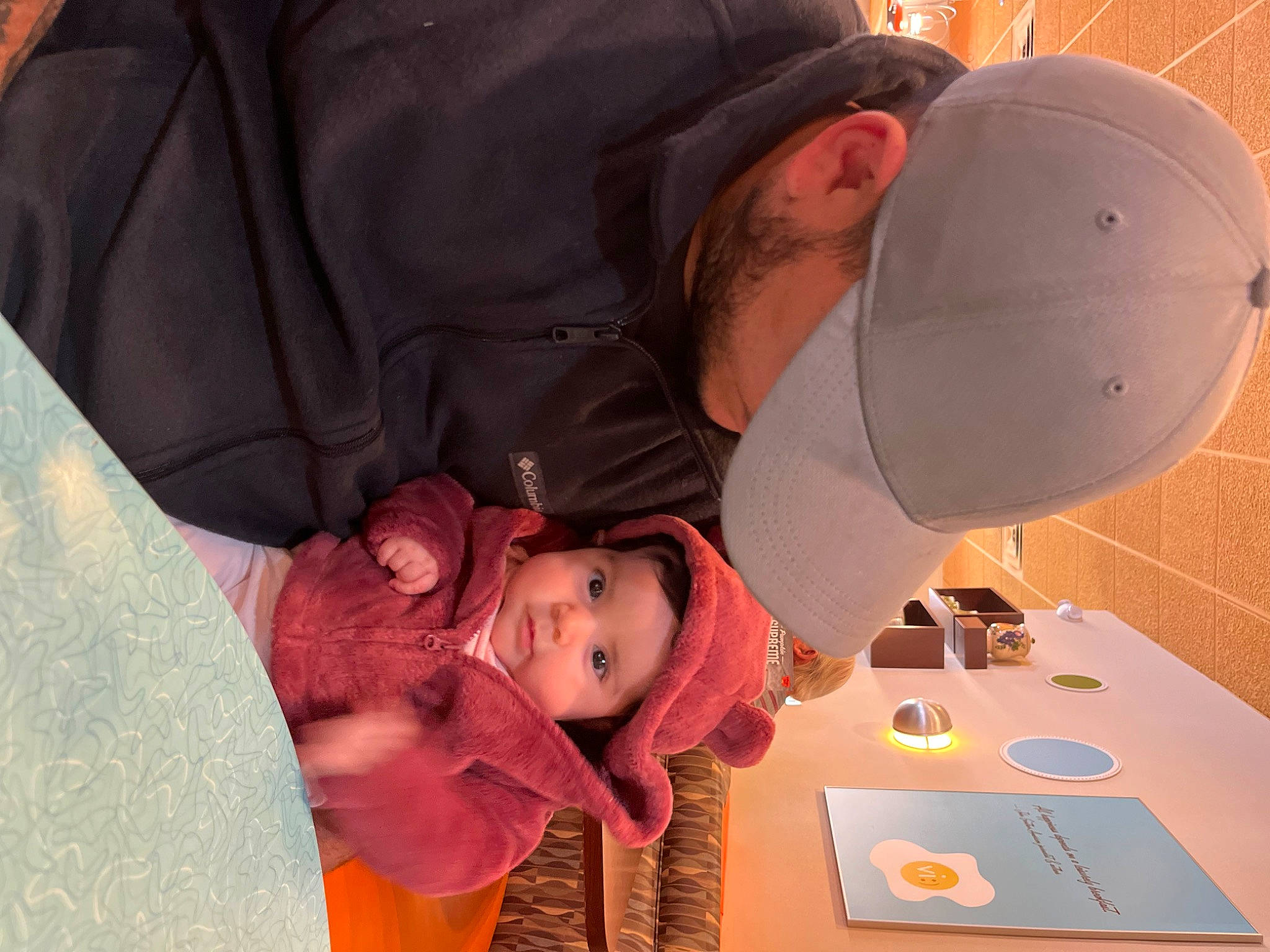 Mía Justina is registered to the contest to win money with this photo: baby, baseball_cap, cap, carmine, child, comfort, event, fun, hat, headgear, headwear, person, personal_protective_equipment, plate, room, t_shirt, table, tableware, toddler
