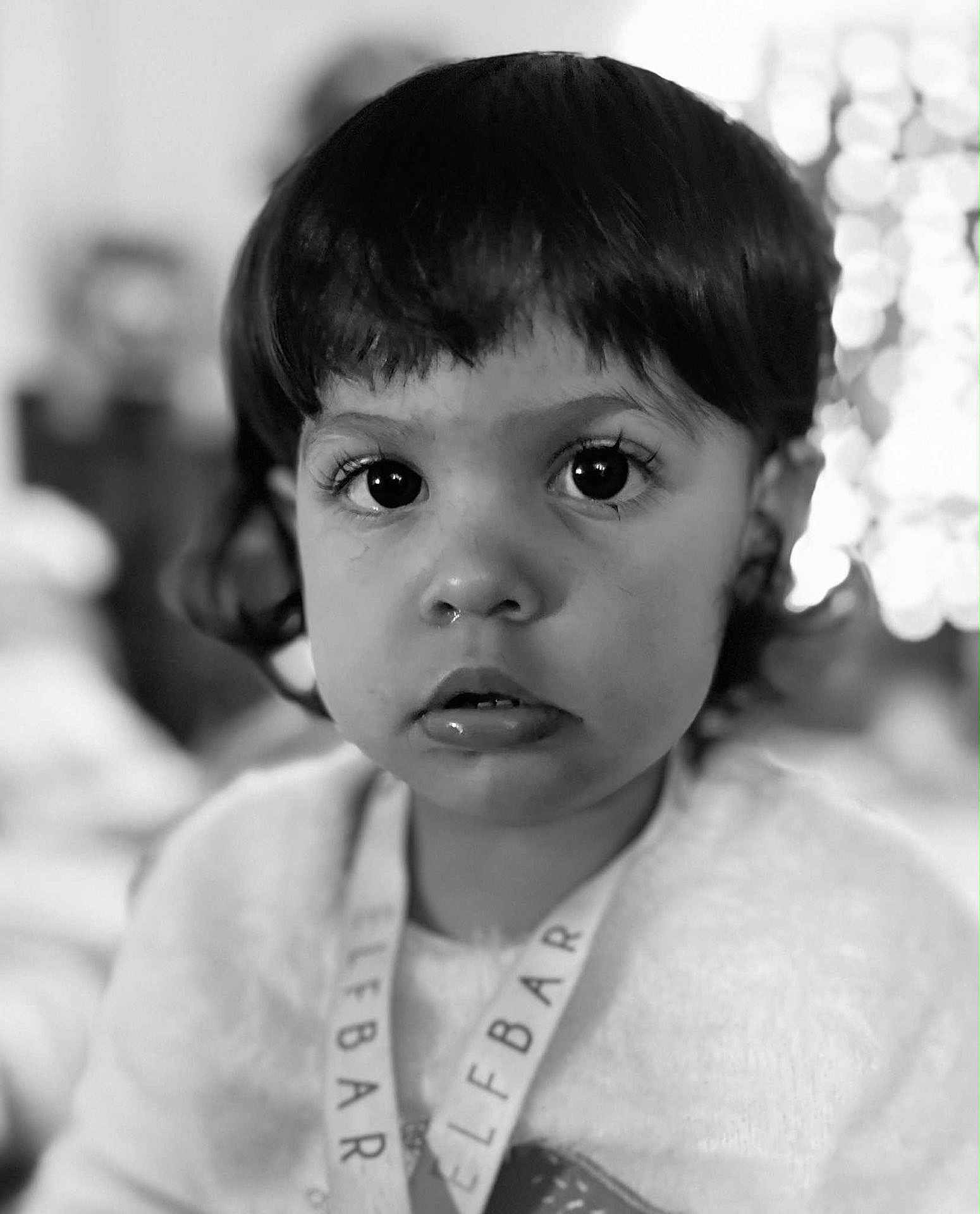 Izué a rejoint le concours — aidez-le/la à gagner de superbes lots ! black_and_white, child, close_up, clothing, curious, curly_hair, cute, expression, face, headshot, indoors, innocent, lanyard, large_eyes, monochrome, person, portrait, soft_focus, toddler, young