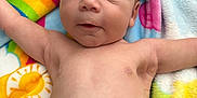 Grayson is registered to the contest to win money with this photo: baby, infant, blanket, colorful, arms_outstretched, face, skin, expression, cute, lying_down, diaper, soft, indoors, newborn, child, person, portrait, head, closeup, resting