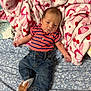 baby, infant, child, striped_shirt, jeans, socks, hand, bed, blanket, pink_blanket, floral_sheet, cute, toddler_hand, sleepy, indoor, portrait, newborn, clothing, fabric, soft
