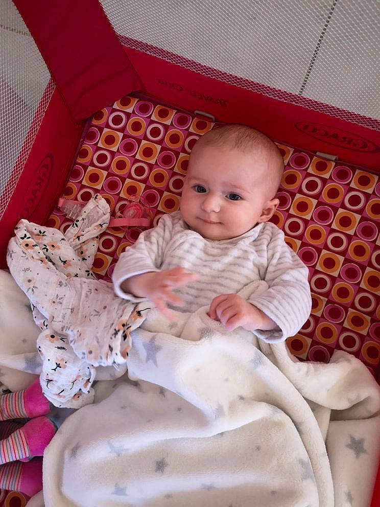 Capucine a rejoint le concours — aidez-le/la à gagner de superbes lots ! baby, baby_products, baby_toddler_clothing, chair, child, comfort, human_leg, lap, leg, person, pink, room, sitting, skin, sleeve, smile, sock, textile, thigh, toddler