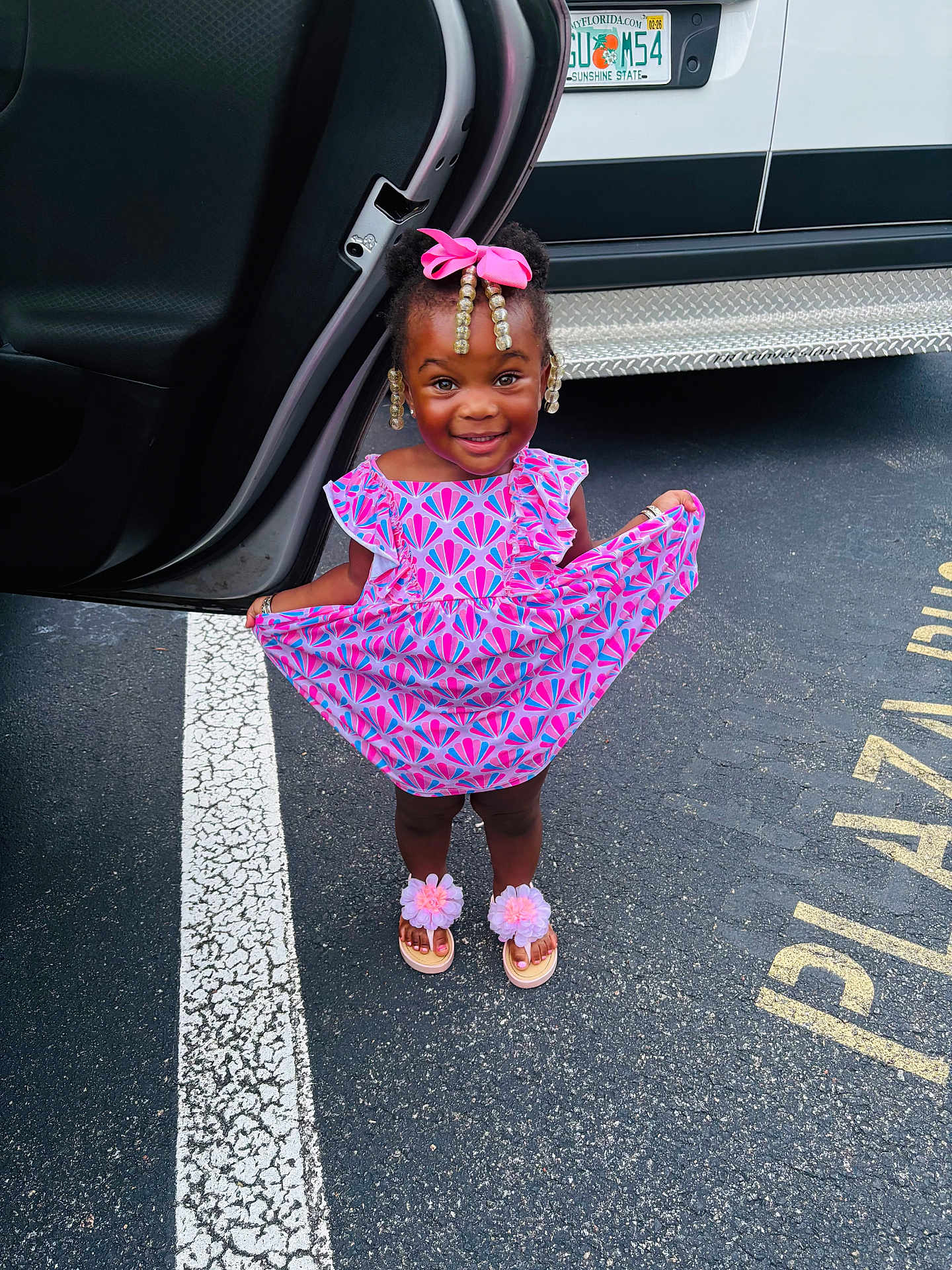 Za Lonnii joined the competition — help win amazing prizes! child, girl, smiling, dress, pink_bow, beads, sandals, flower_sandals, parking_lot, car_door, license_plate, asphalt, white_line, standing, happy, outdoor, person, cute, fashion, accessories