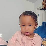 Serenity is registered to the contest to win money with this photo: toddler, child, indoor, person, pink_clothing, toy, drool, cute, baby, portrait, face, hand, sitting, young_child, earring, curly_hair, casual_wear, home, relaxed, expression