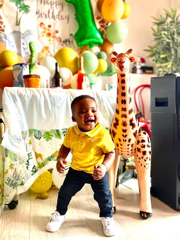 Elijah participe au concours pour gagner de l'argent avec cette photo : adaptation, art, child, event, fun, giraffe, giraffidae, green, happy, leisure, party_supply, person, photograph, room, shorts, smile, snapshot, t_shirt, textile, toddler