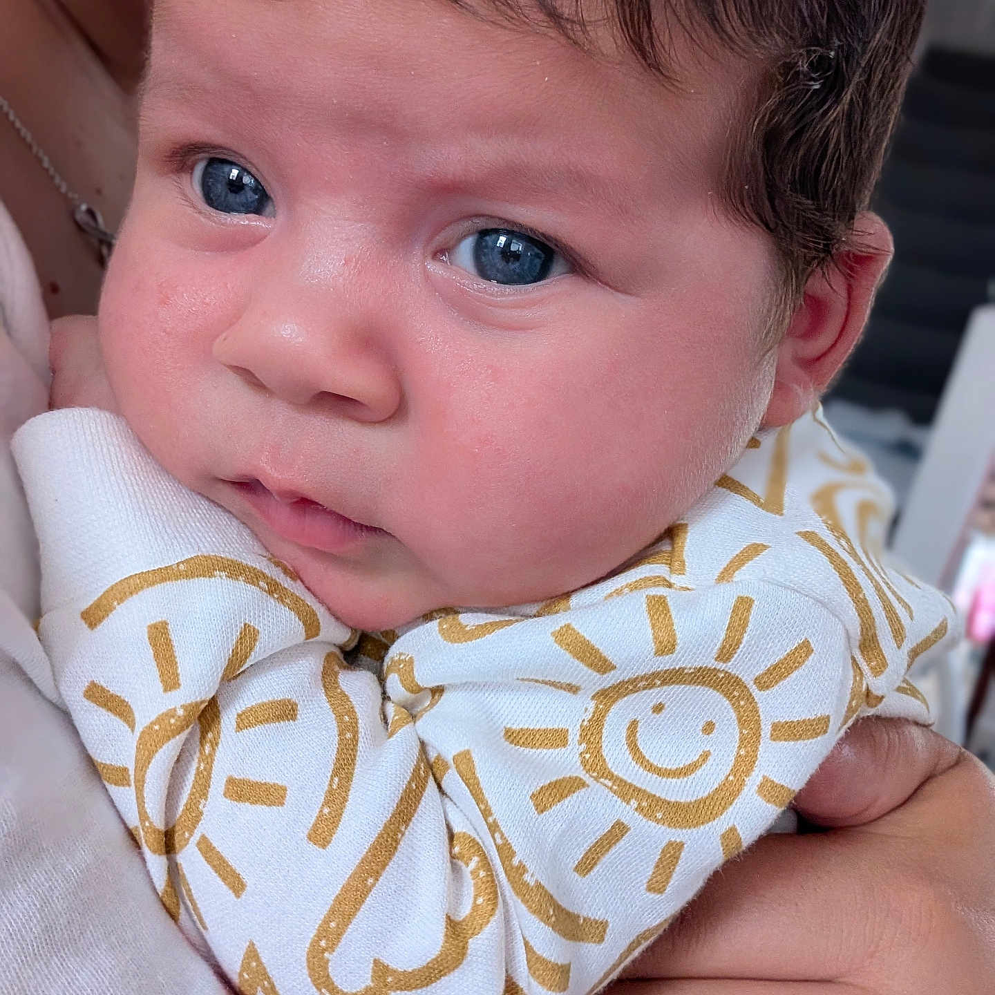 Maria-Cezara is registered to the contest to win money with this photo: baby, infant, blue_eyes, close_up, face, skin, clothing, pattern, sun, hand, holding, person, cute, expression, portrait, newborn, child, indoor, soft_light, warm