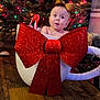 Tinsley joined the competition — help win amazing prizes! baby, bow, teacup, christmas_tree, holiday_decor, gift_wrap, sparkle, wood_floor, indoors, face, child, festive, decorations, present, cute, surprised_expression, holiday_lights, headband, seasonal, celebration