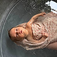 Alix a rejoint le concours — aidez-le/la à gagner de superbes lots ! baby, infant, water, tub, cloth, floating, skin, peaceful, newborn, arm, hand, face, head, pattern, reflection, bath, wet, container, soft_light, indoors