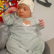 Safi a rejoint le concours — aidez-le/la à gagner de superbes lots ! baby, infant, onesie, hat, person, hand, face, table, toy, building_blocks, colorful, clothing, sitting, indoor, soft_fabric, cute, child, resting, lap, accessory