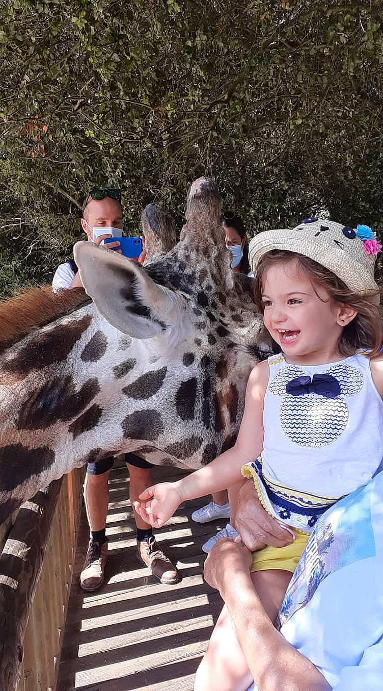 Léana participe au concours pour gagner de l'argent avec cette photo : beauty, child, event, fawn, foot, fun, fur, giraffe, giraffidae, happy, hat, landscape, leisure, person, recreation, smile, sun_hat, terrestrial_animal, toddler, white