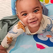 Niko is registered to the contest to win money with this photo: baby, child, crawling, smiling, toy, blanket, playmat, indoor, infant, cute, happy, colorful, clothing, face, person, soft, comfort, home, early_childhood, expression