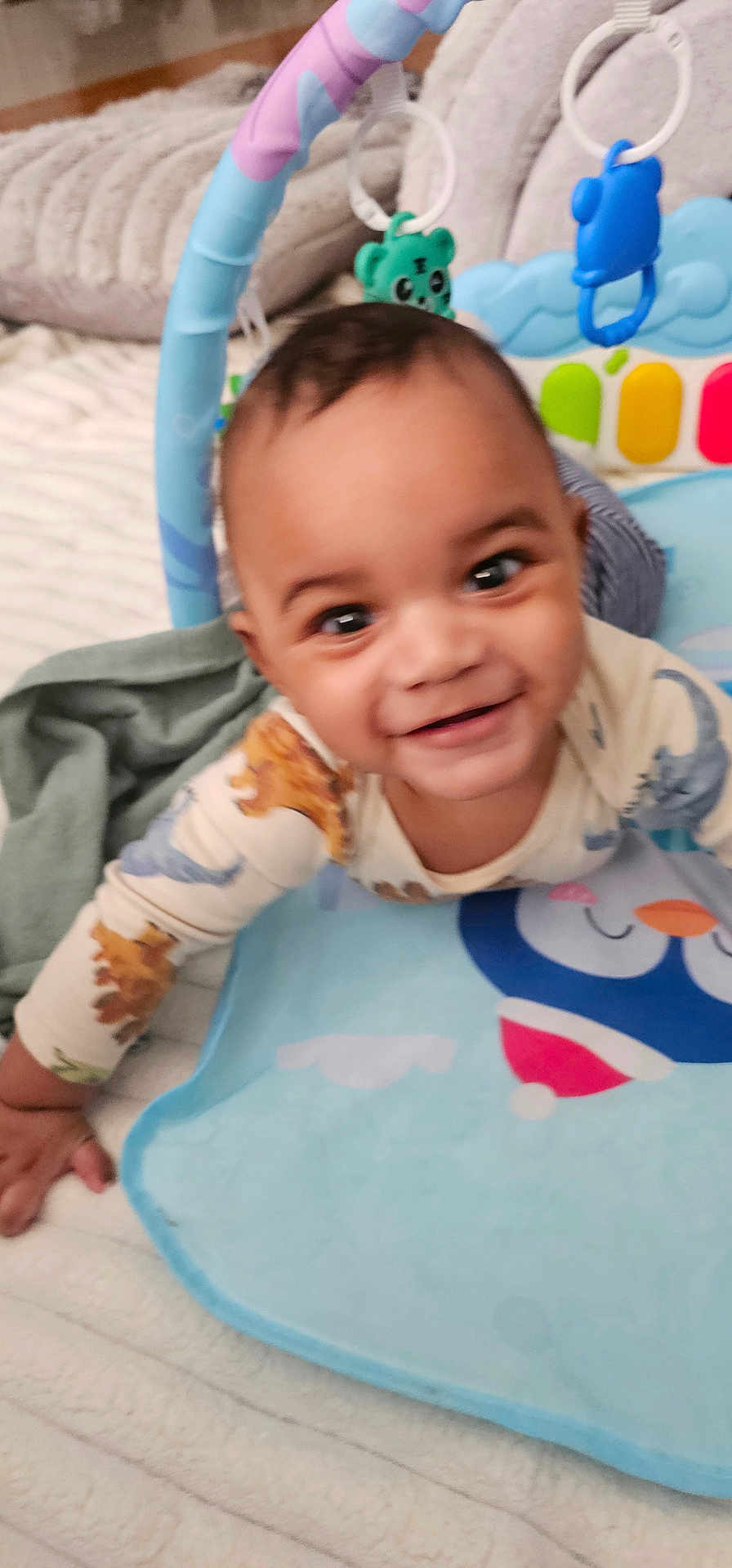 Niko is registered to the contest to win money with this photo: baby, child, crawling, smiling, toy, blanket, playmat, indoor, infant, cute, happy, colorful, clothing, face, person, soft, comfort, home, early_childhood, expression