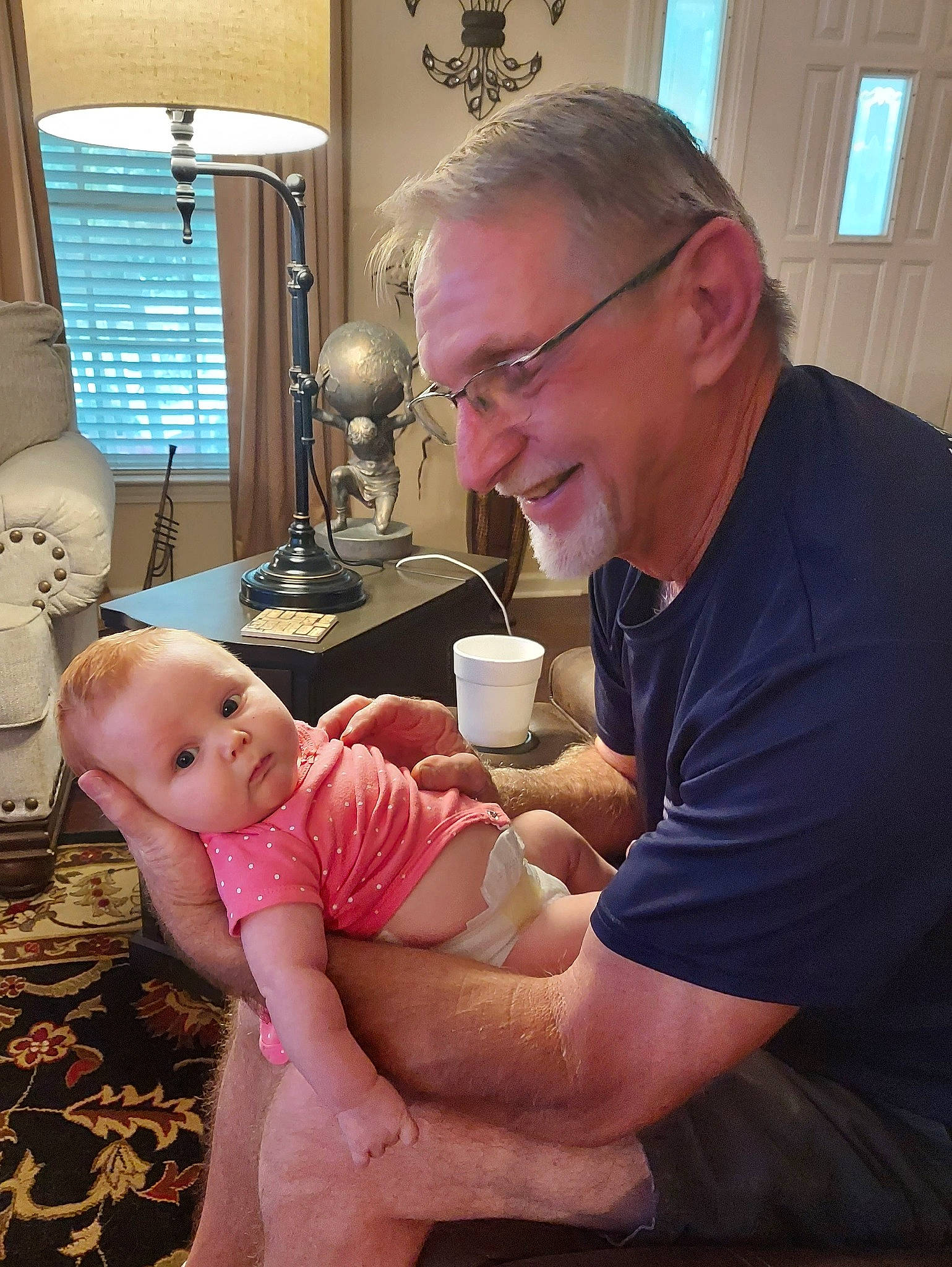 Andi is registered to the contest to win money with this photo: abdomen, baby, chest, child, comfort, event, eyewear, foot, happy, joy, lamp, lap, mouth, person, room, service, sitting, smile, stomach, thigh