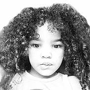 Dezariah joined the competition — help win amazing prizes! child, portrait, face, curly_hair, black_and_white, closeup, serious, looking_at_camera, eyes, nose, mouth, shirt, rainbow, indoor, headshot, photography, young_person, hair, monochrome, safe