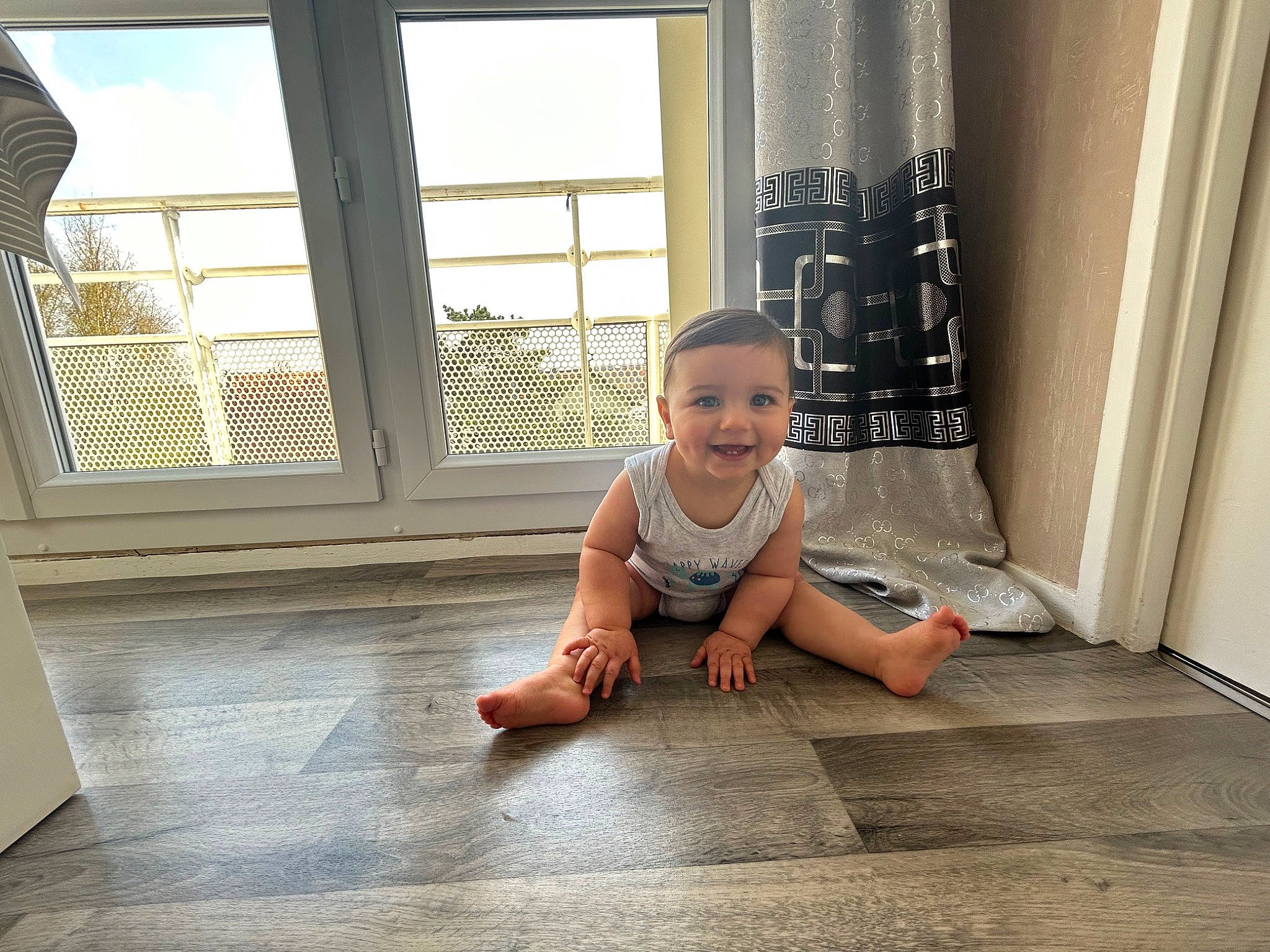 Nayl participe au concours pour gagner de l'argent avec cette photo : baby, baby_toddler_clothing, barefoot, child, crawling, curtain, floor, flooring, foot, fun, happy, hardwood, human_leg, joy, laminate_flooring, person, room, smile, toddler, window