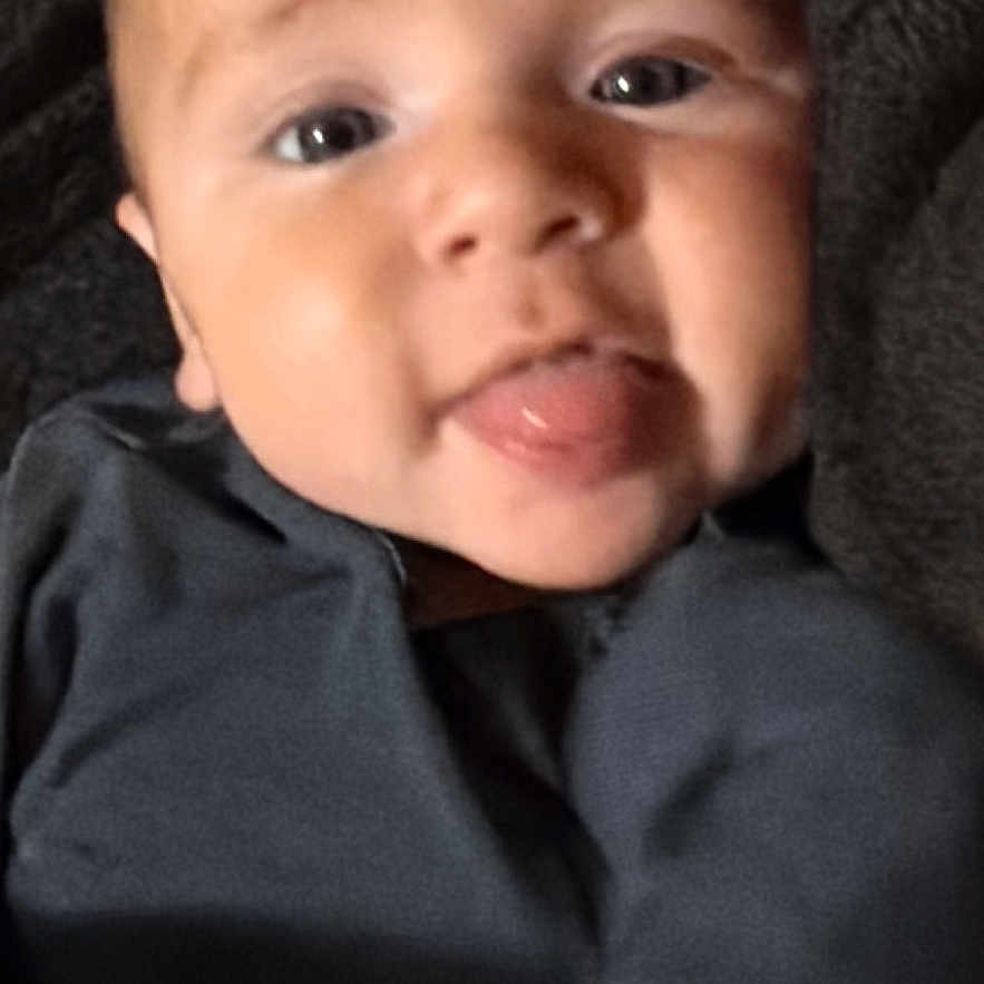 Khamilo joined the competition — help win amazing prizes! baby, blanket, child, close_up, clothing, cozy, cute, expression, face, gray_clothing, indoor, infant, looking_at_camera, lying_down, photography, portrait, sitting, sticking_out_tongue, tongue, wrapped