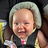 baby, infant, car_seat, child, smile, happy, seatbelt, straps, face, head_support, clothing, yellow, pink, pattern, cute, closeup, portrait, safety, indoor, person
