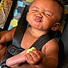 baby, child, car_seat, food, snack, funny_face, expression, seatbelt, infant, cute, skin, hand, mouth, lips, black_hair, indoor, closeup, person, holding, seat