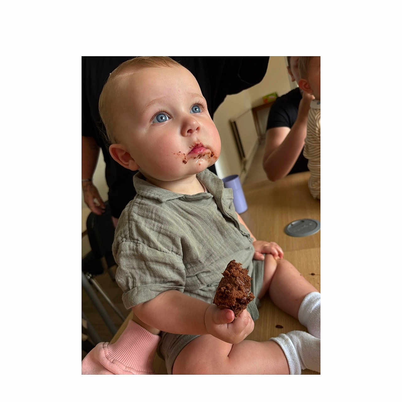 Elijah is registered to the contest to win money with this photo: baby, blue_eyes, cake, casual, child, chocolate, clothing, cute, face, family, food, hand, happy, indoor, messy, mouth, person, sitting, snack, table