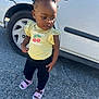 Armani joined the competition — help win amazing prizes! toddler, child, yellow_shirt, pink_sandals, hair_accessory, crown, standing, car, white_car, outdoor, sidewalk, sunny, curly_hair, black_pants, earrings, cute, confident, person, street, casual_clothing