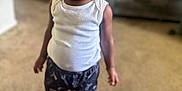 Armani is registered to the contest to win money with this photo: toddler, child, sunglasses, white_tank_top, patterned_shorts, pink_shoes, carpet, indoor, hair_bow, standing, person, eyewear, fashion, cute, confident, casual_clothing, black_hair, earrings, smiling, home