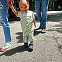 Quintrell joined the competition — help win amazing prizes! toddler, child, adult, holding_hands, overalls, short_sleeve_shirt, walking, outdoor, pavement, shoes, sunlight, shadow, trees, casual_clothing, jeans, sandals, smiling, happy, family, daytime