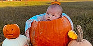 Mayzie is registered to the contest to win money with this photo: baby, infant, pumpkin, jack_o_lantern, gourd, grass, field, autumn, fall, outdoor, sky, farm, house, sunset, portrait, cute, bare_feet, blanket, carving, seasonal