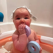 Mayzie joined the competition — help win amazing prizes! baby, infant, bathtub, bath, toy, stacking_toys, pastel_colors, washcloth, towel_hat, water, wet_skin, chubby_cheeks, hand, face, eyes, plastic_toy, bathroom, sitting, playful, toddler