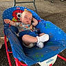 baby, sleeping, baby_rocker, blue, colorful, cartoon, animal_print, sock, clothing, infant, peaceful, resting, seat, toy, indoor, floor, metal_frame, cute, child, relaxing