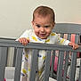 Miles joined the competition — help win amazing prizes! toddler, baby, crib, onesie, child, smile, baby_clothes, nursery, furniture, blanket, bedroom, grip, hand, standing, indoor, person, face, expression, cute, home