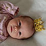 adorable, baby, blanket, child, crown, cute, face, gold, head, infant, lying_down, newborn, onesie, pearl, pink_clothing, portrait, resting, royalty, soft_texture, young