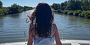 Emelyne a rejoint le concours — aidez-le/la à gagner de superbes lots ! child, girl, boat, river, water, sunlight, sky, nature, trees, outdoor, summer, back_view, relaxation, calm, scenery, travel, vacation, daytime, watercraft, serene