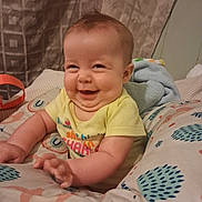 Alita is registered to the contest to win money with this photo: baby, blanket, child, chubby, clothing, cozy, curtain, cute, cute_expression, face, hand, happy, home, indoors, infant, patterned, pillow, portrait, sitting, smile