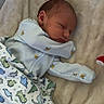 Deacon is registered to the contest to win money with this photo: newborn, baby, sleeping, infant, portrait, blanket, swaddle, onesie, clothing, bees, dinosaurs, patterned, crib, bedding, cozy, indoors, peaceful, face, resting, nursery