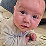 baby, infant, tummy_time, play_mat, indoor, curious, face, eyes, smile, cozy, blanket, couch, floor, child, person, young, cute, skin, clothing, head