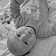 Lowen a rejoint le concours — aidez-le/la à gagner de superbes lots ! baby, infant, blanket, moon_patch, toys, onesie, floor_tiles, black_and_white, lying_down, curious_expression, soft_fabric, indoor, child, cute, portrait, head, hand, clothing, playtime, peaceful