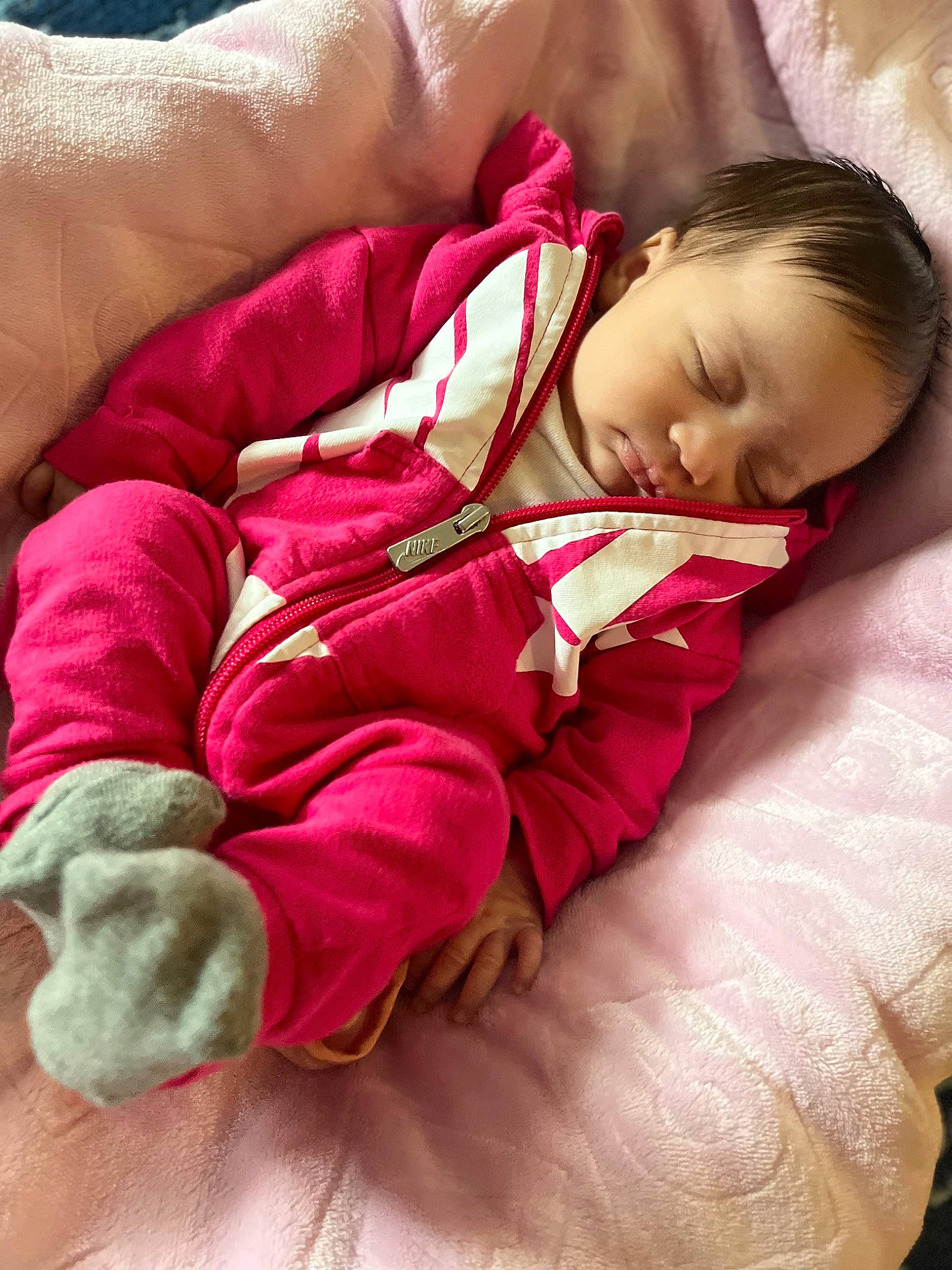 Isabelle is registered to the contest to win money with this photo: baby, baby_sleeping, baby_toddler_clothing, bedding, comfort, finger, gesture, hand, head, human_leg, knee, leg, linens, magenta, person, pink, skin, sock, thigh, thumb