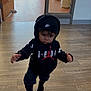 toddler, child, hoodie, beanie, indoor, walking, flooring, wood_floor, person, clothing, black_clothing, headwear, curly_hair, young_child, casual, nike, jordan, determined, serious_face, movement