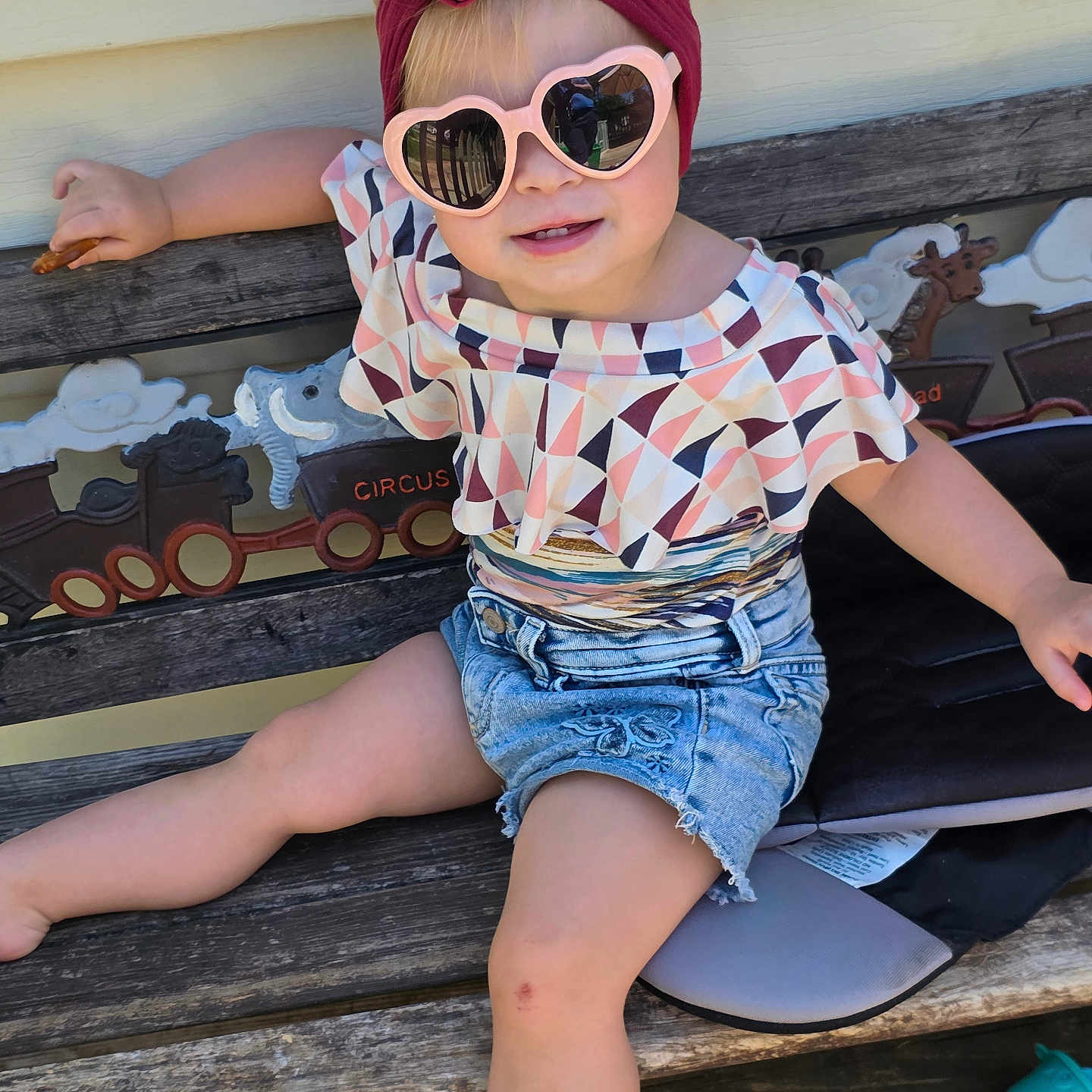 Milica joined the competition — help win amazing prizes! barefoot, bench, carving, casual_pose, child, circus, cute, daylight, fashion, headband, outdoor, patterned_top, playful, scuff, shorts, smile, sunglasses, toddler, toy, wood