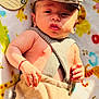 baby, infant, hat, suspenders, blanket, animal_print, sunlight, cute, child, portrait, clothing, hand, face, skin, newborn, lying_down, indoors, soft_texture, expression, baby_fashion