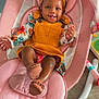 baby, infant, smiling, child, headband, yellow_dress, pink_rocker, cushion, toy, wooden_floor, happy, indoor, person, cute, footwear, sitting, portrait, childcare, colorful, relaxed