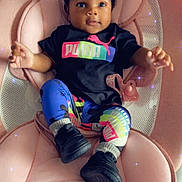 Lay Ani is registered to the contest to win money with this photo: baby, infant, child, puma, colorful_clothing, hair_bows, black_shoes, pink_cushion, seat, indoor, sparkles, cute, portrait, relaxing, fashion, legs, hands, smiling, face, person