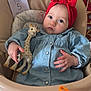 baby, infant, girl, red_headband, giraffe_toy, milestone_card, highchair, denim_dress, polka_dot_pillow, toy, hands, blue_eyes, chubby_cheeks, looking_at_camera, portrait, indoor, cute, feeding_tray, seat, soft_lighting